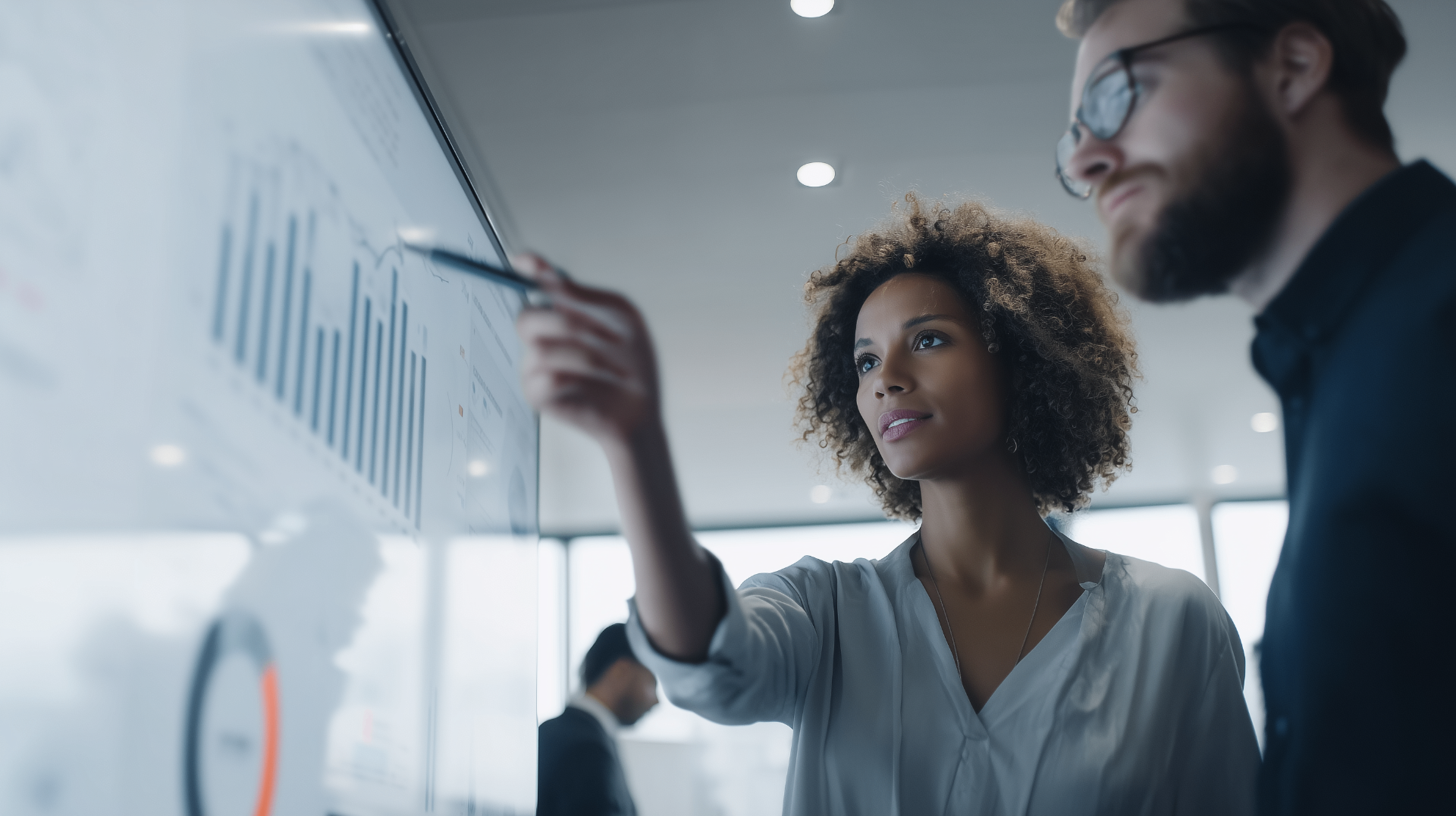 Two strategists reviewing growth charts on a large analytics display